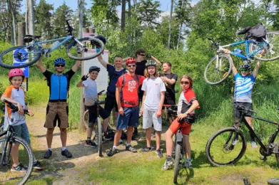 grupa ojców z nastolatkami na rowerach w lesie