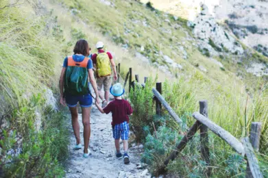 kobieta idąca za rękę z synkiem na szlaku górskim. Ujęcie od tyłu.