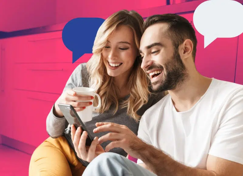 Uśmiechnięta para przeglądająca coś na telefonie.