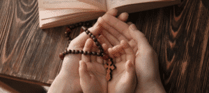 Różaniec na rękach dziecka i taty