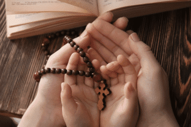 Różaniec na rękach dziecka i taty