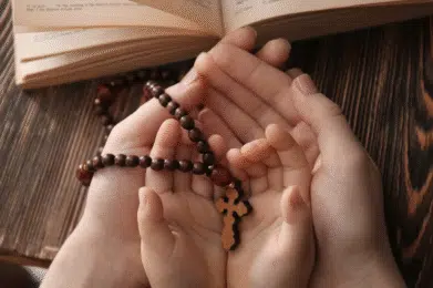 Różaniec na rękach dziecka i taty