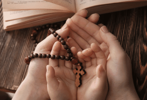 Różaniec na rękach dziecka i taty