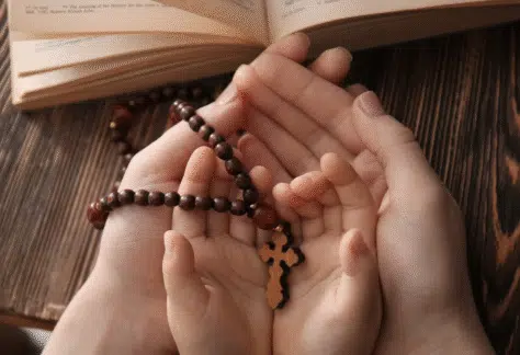 Różaniec na rękach dziecka i taty