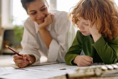 Talenty dziecka. mama z synem wspólnie robią zadanie na podłodze.
