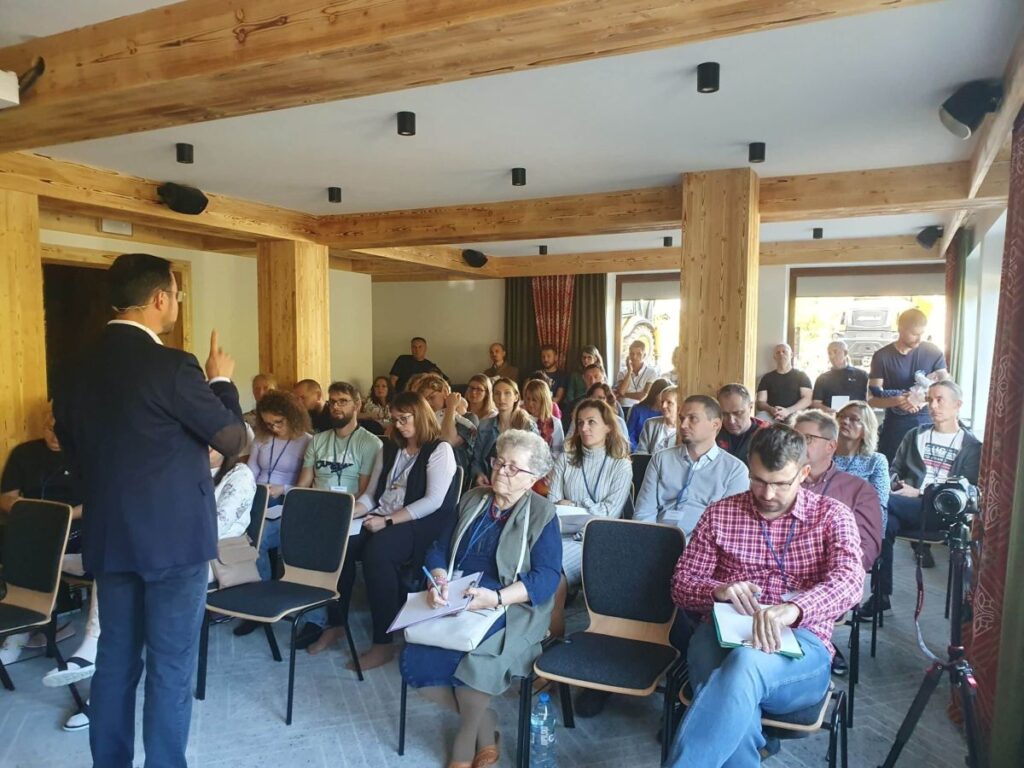 Prelegent w sali konferencyjnej prowadzi wykład dla zainteresowanej publiczności.